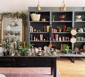 The Someday Shop in Richmond shows a bookshelf with vintage goods and a table filled with house wares
