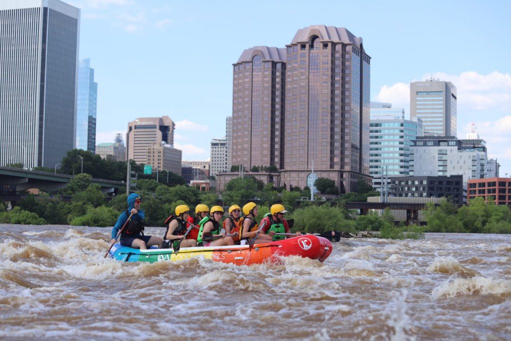 A whitewater raft travels past downtown richmond