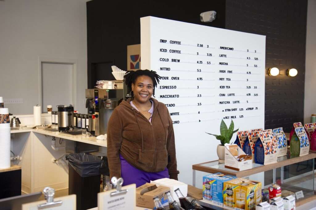 The owner of a local Richmond coffee shop standing at the counter